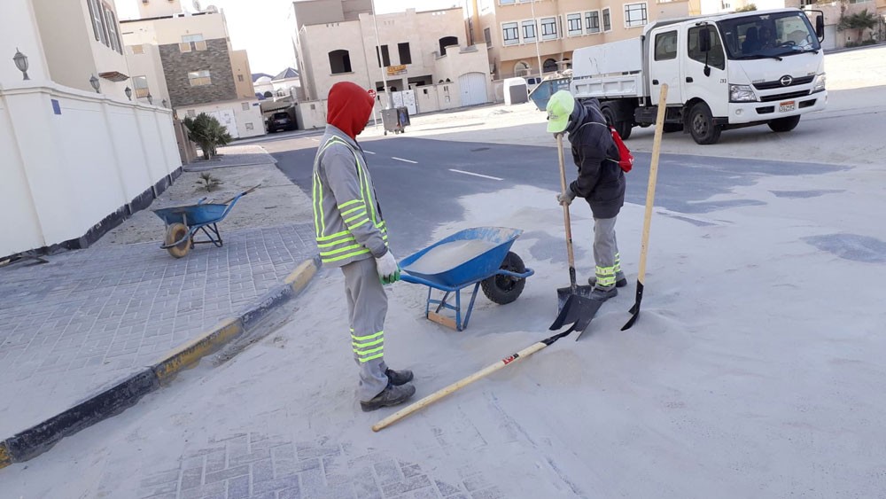 بلدية المحرق تنفذ حملة إزالة للرمال المتراكمة على الشوارع الرئيسية