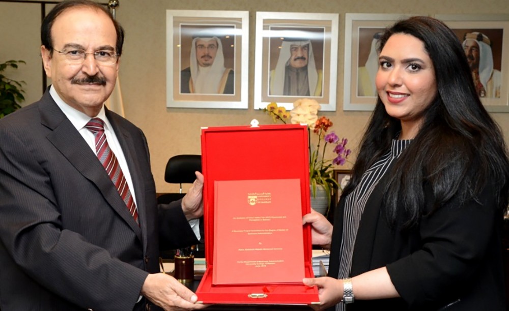 ميرزا يتسلم نسخة من رسالة الماجستير للموظفة ريم الموسى