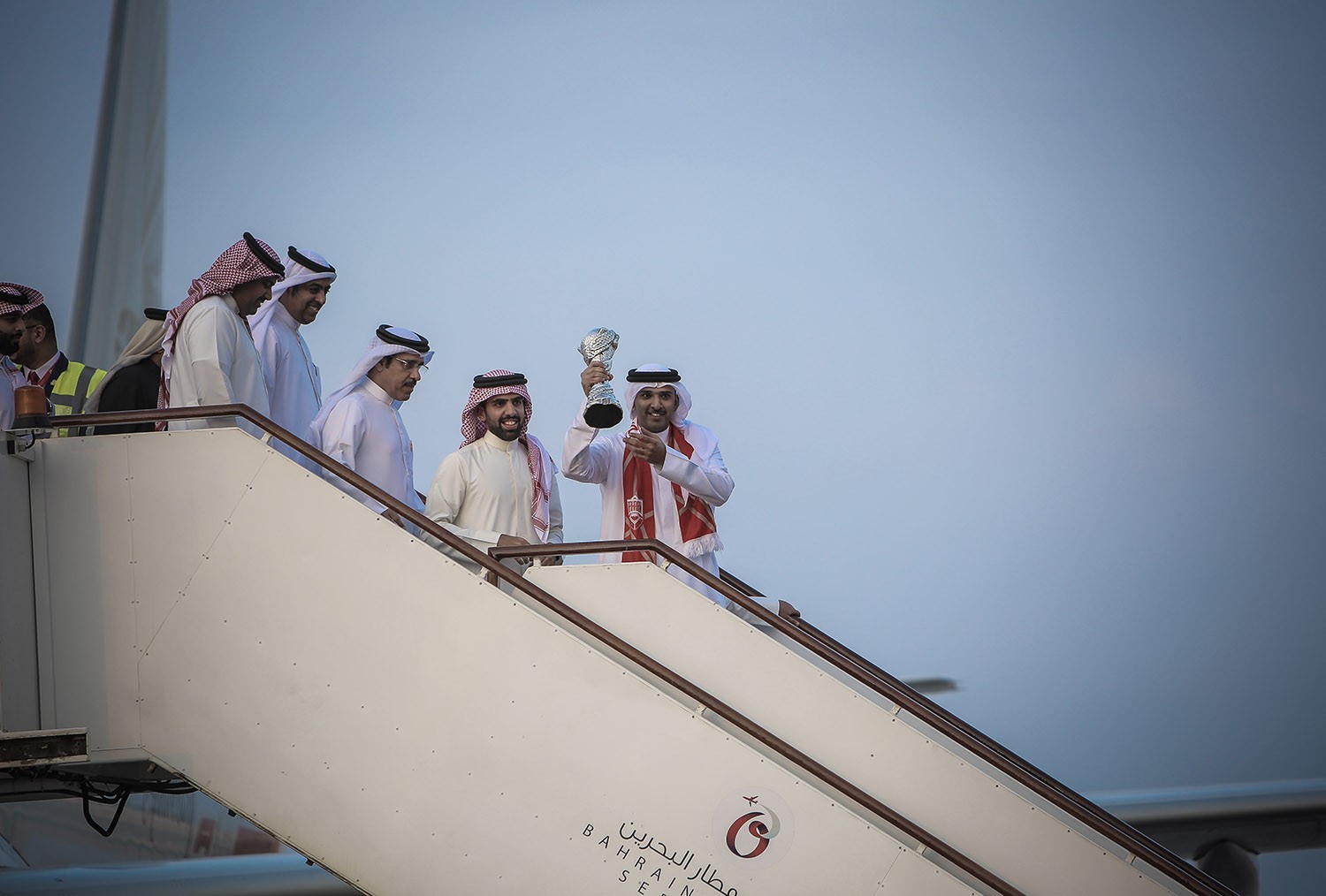 بالصور: رجال الأحمر يصلون أرض الوطن بكأس الخليج.. والآلاف يحيونهم بالأعلام والورود