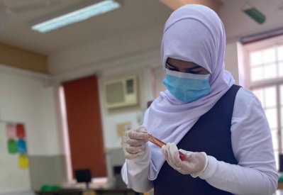 طلبة الحضور الفعلي يطبقون التجريب العلمي والاستكشاف بمختبرات العلوم
