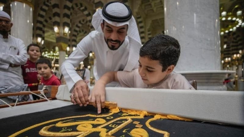 بالصور: زوار المسجد النبوي يشاركون في حياكة كسوة الكعبة المشرفة