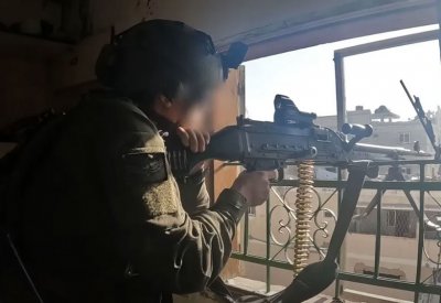 جندي إسرائيلي يلقي قنبلة صوت على مكتب وزارة الدفاع