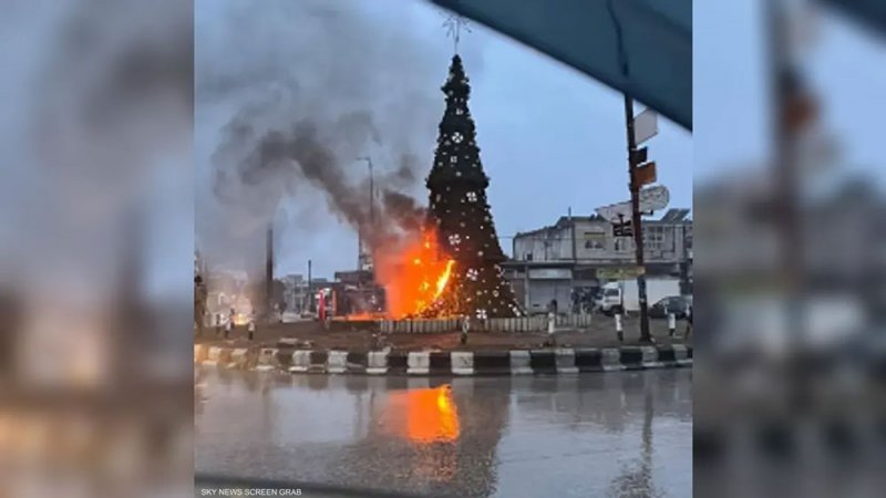 مسلحون ملثمون يضرمون النار في شجرة الميلاد بحماة