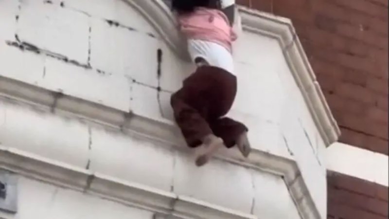 لقطات تحبس الأنفاس.. طفلة كادت تسقط من نافذة منزلها لولا تدخل الشرطة